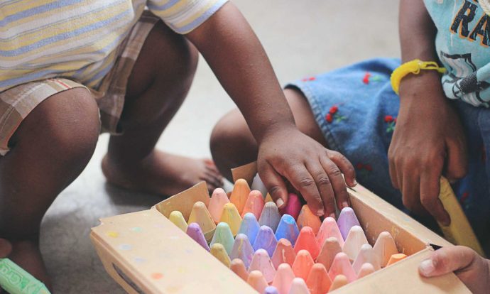 Children playing with crayons in nursery